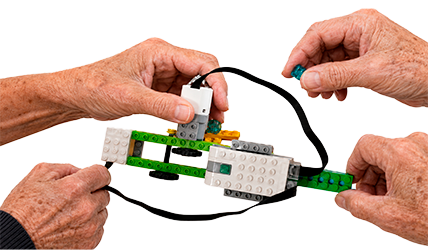 Adultos mayores construyendo robot Robotikids